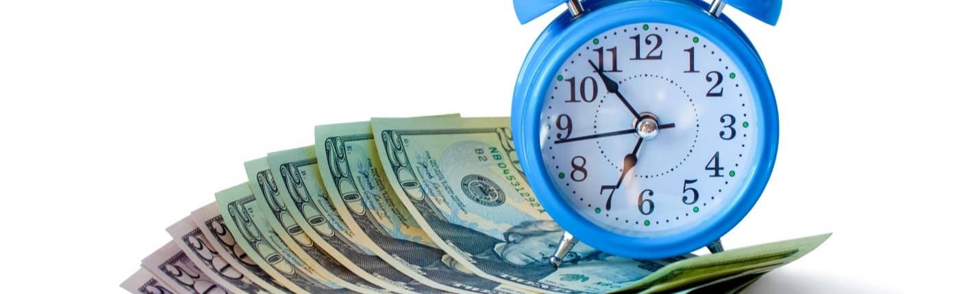 Blue alarm clock on money.