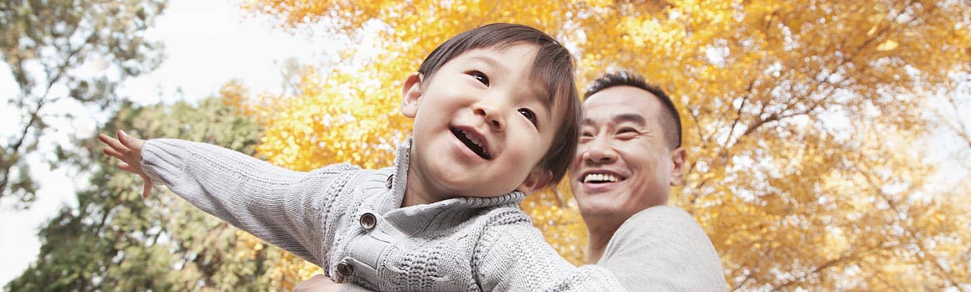 father plays with his son outside in fall and plans a financial checklist for his single-parent finances