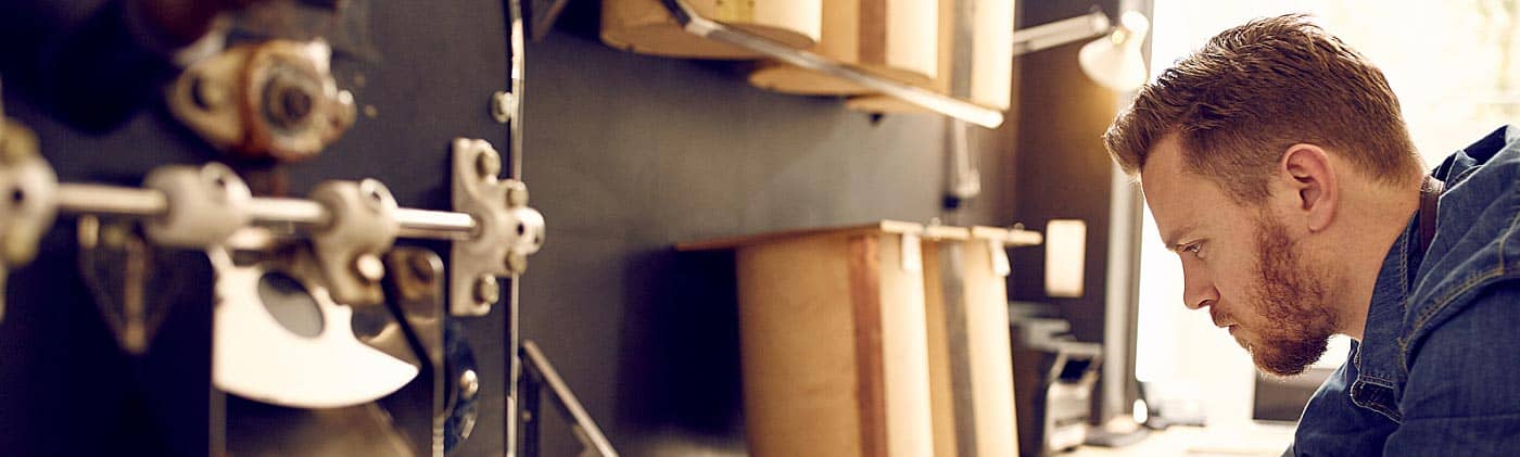 man researches business valuation methods online in his shop to answer: what is my business worth?