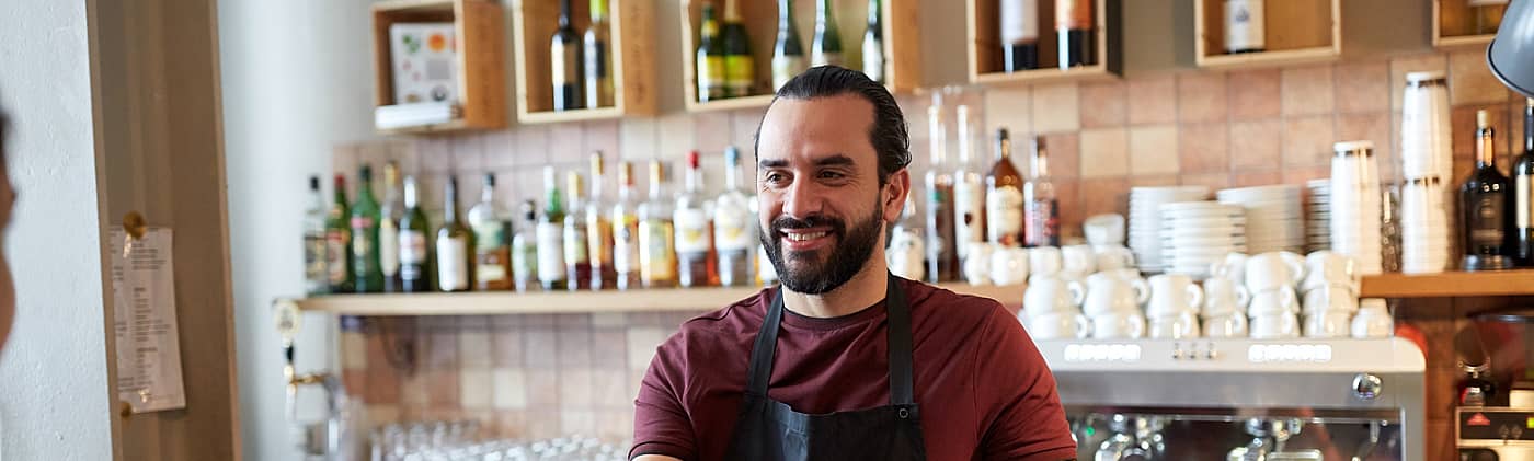 café owner takes customer’s credit card and thinks how to maximize his small business tax deductions