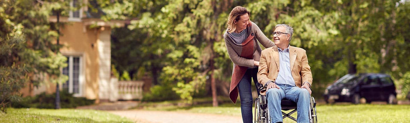 a woman goes for a walk with her father who is in a wheelchair disability income insurance