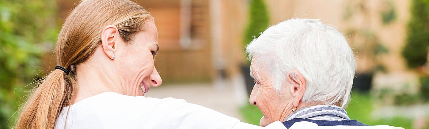 a young caretaker walks with an elderly woman advantages of long term care insurance