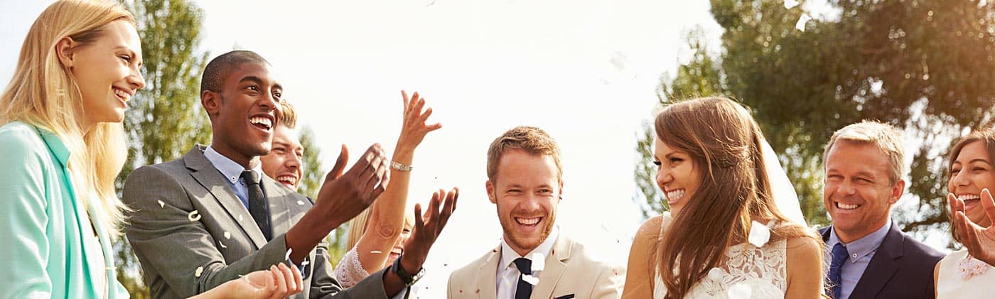 friends throw confetti at bride and groom and counsel them later about when should you get life insurance