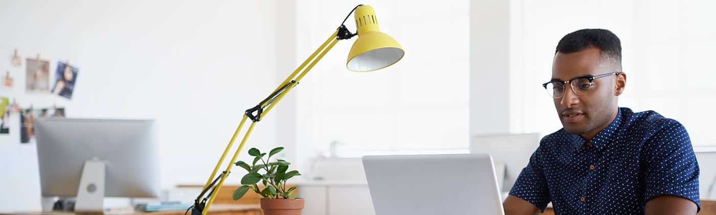 African American male on computer researching where to invest after maxing out his 401(k) 