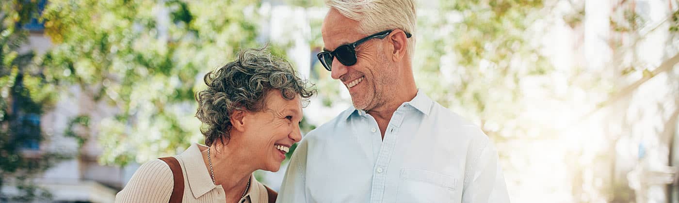 An older couple laughing and talking after looking at a house for retirement 
