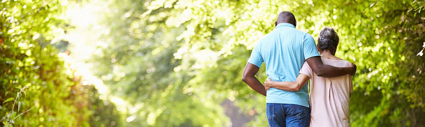 An older couples walks on a trail and discusses their IRA 