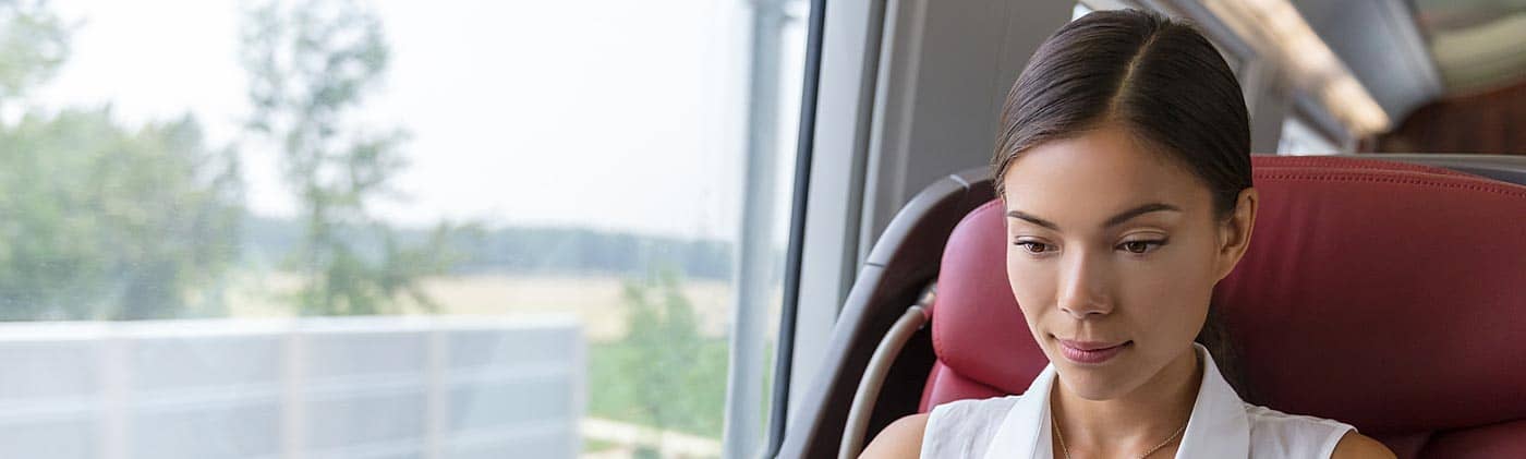 businesswoman researches the difference between a 401(k) and IRA while traveling by train for work