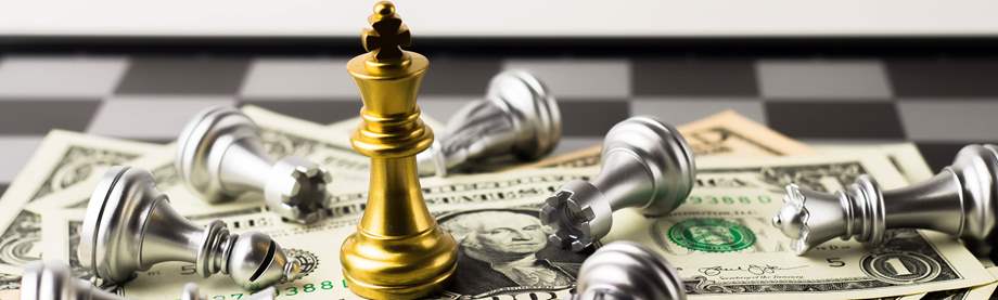 king chess piece on top of dollar bills