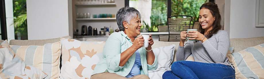 Two ladies enjoying a laugh over a cup of coffee