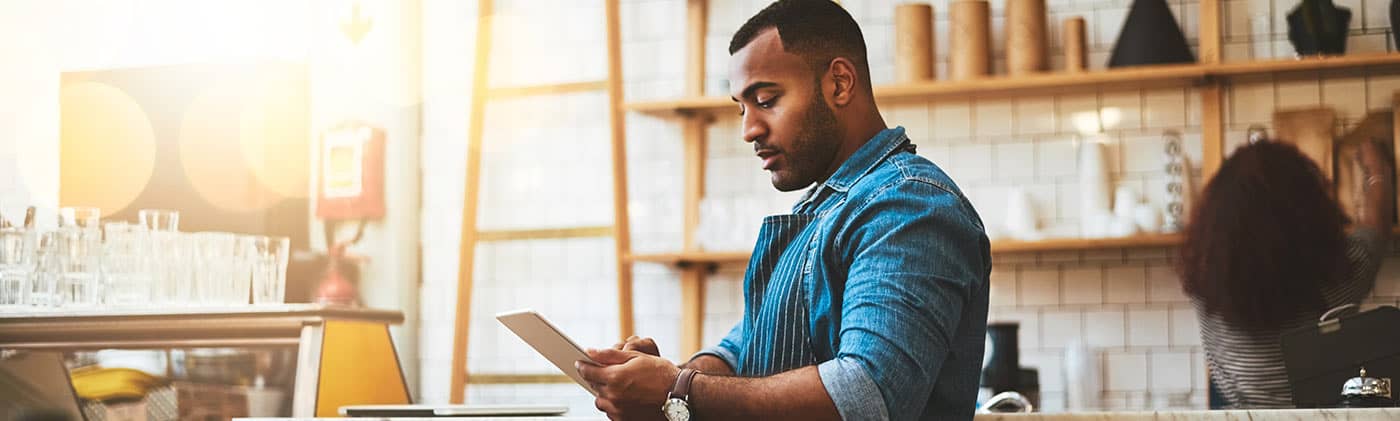 Gentleman in the kitchen checking his recipe on his notebook