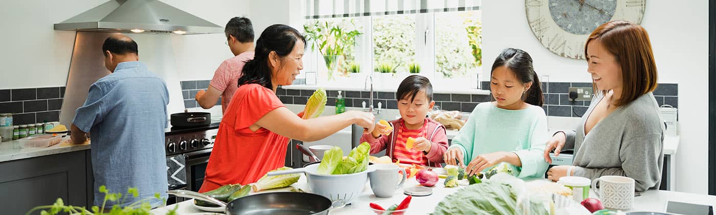The entire family in the kitchen preparing a meal