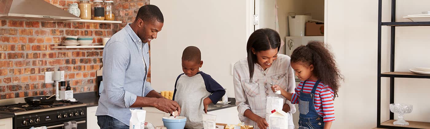 Mom and dad with son and daughter baking in the kitchen