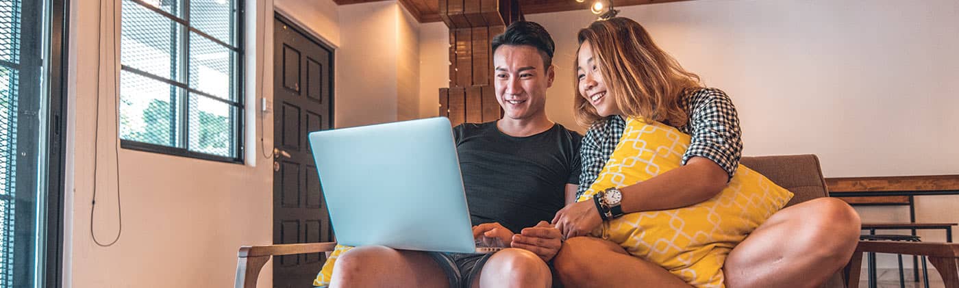 Couple on couch finances laptop money management for couples 6 tips for stronger finances