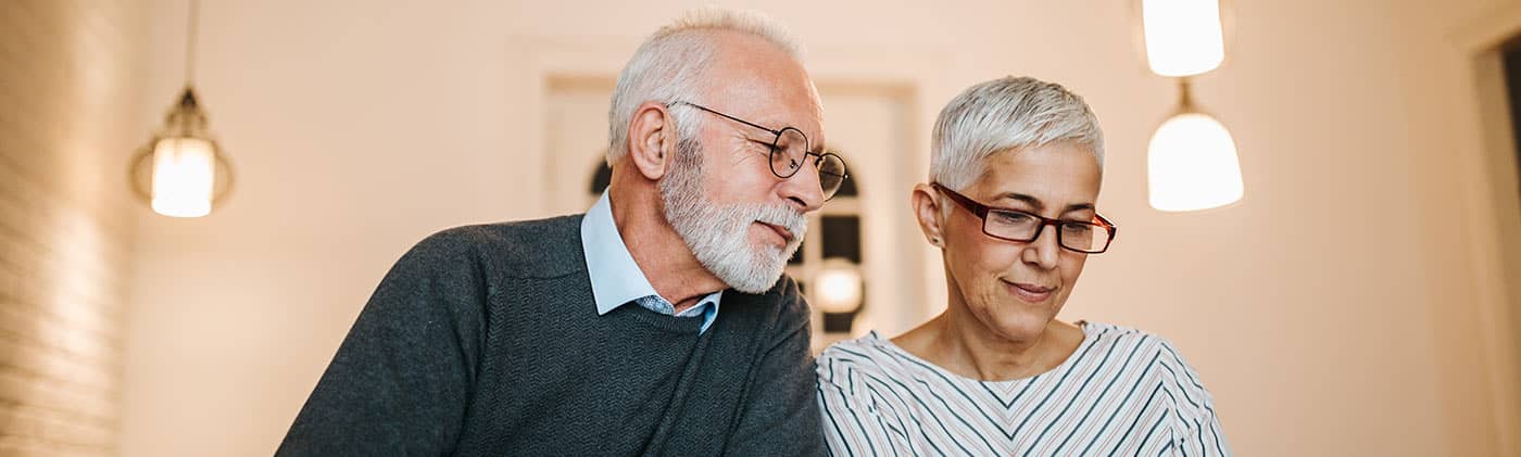 retired couple at home researching the question: what does the average funeral cost?