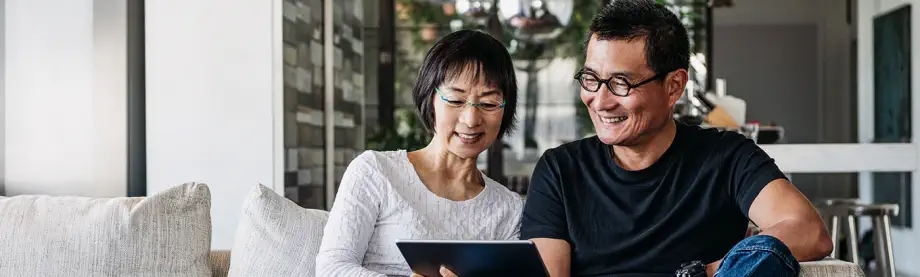 couple on sofa looking at ipad