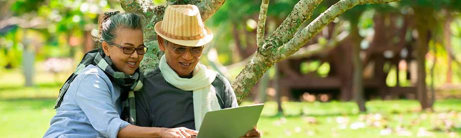 Mature couple sitting under a tree looking up how many IRAs they can have