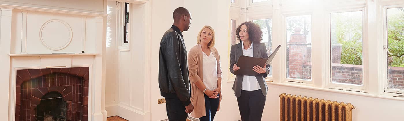 Couple viewing home with agent will you hire a real estate agent