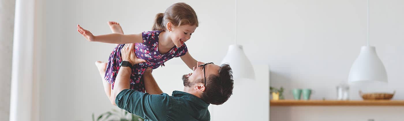 Dad and daughter having fun after dad researched how life insurance works 