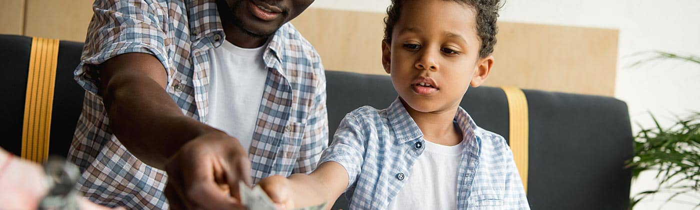 Father showing his young son how to pay a restaurant bill: financial literacy