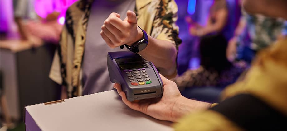 Man uses watch to pay for shoes.