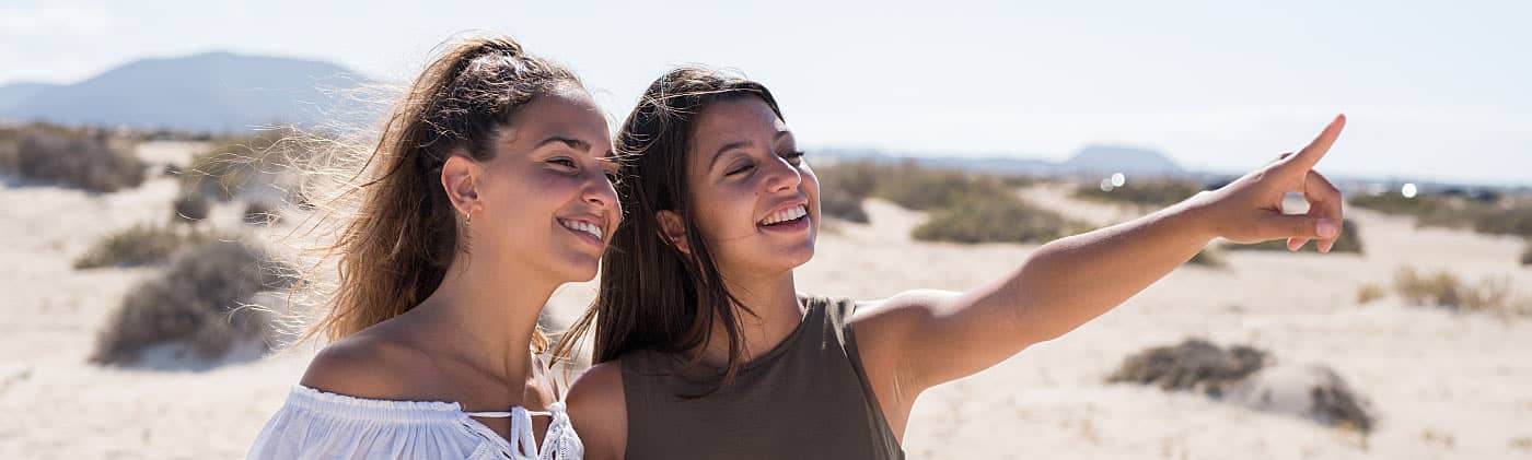 Friends on the beach discuss how to invest in your 20s
