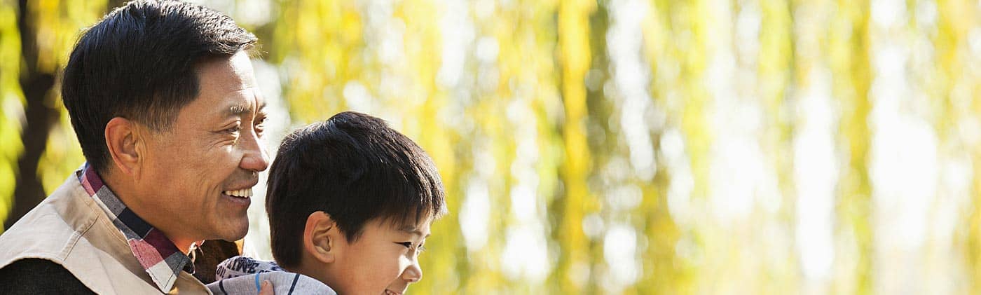 Smiling grandfather and grandson fishing together: difference between term and whole life insurance