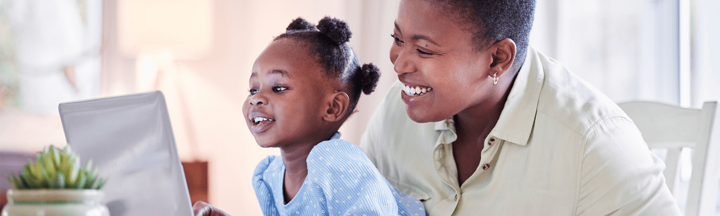 Grandma shows granddaughter how to budget on computer. 