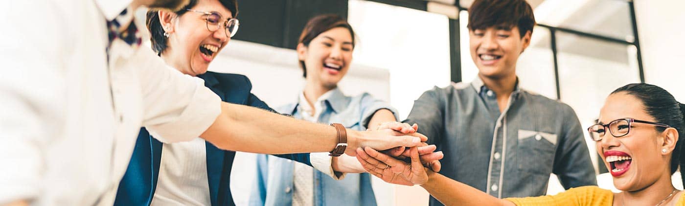 Group of young professionals engaged in a group huddle: buy life insurance