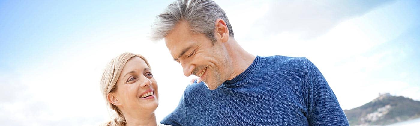 Happy couple walking along the beach: single-premium life insurance