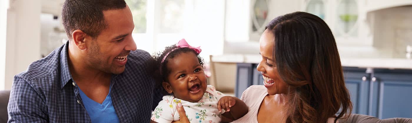 mother and father think about 20-year term life insurance as they play with their toddler daughter
