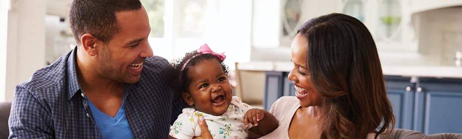 mother and father think about 20-year term life insurance as they play with their toddler daughter