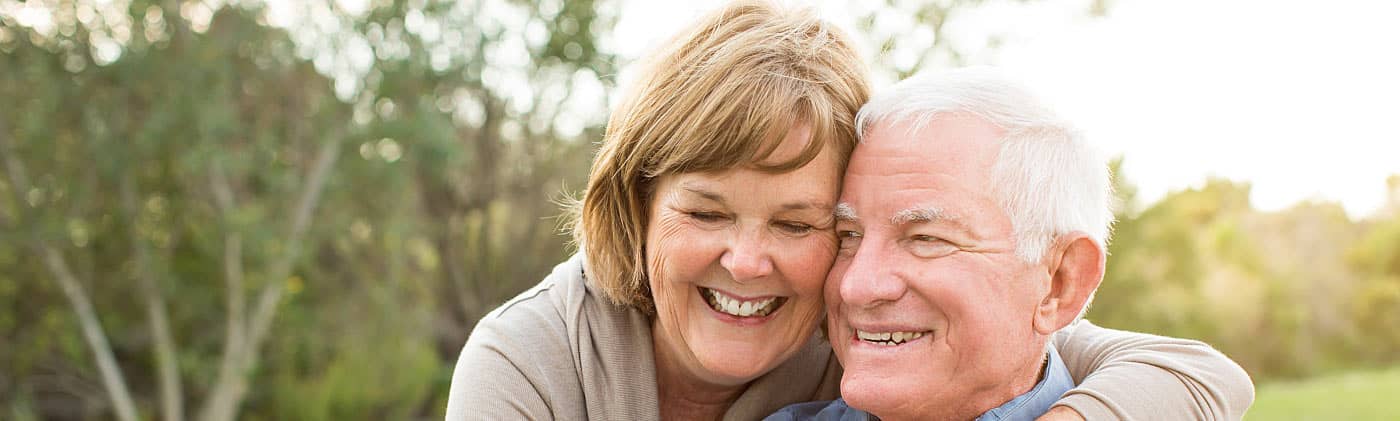 Happy senior couple enjoying the outdoors and discussing when to start claiming social security 