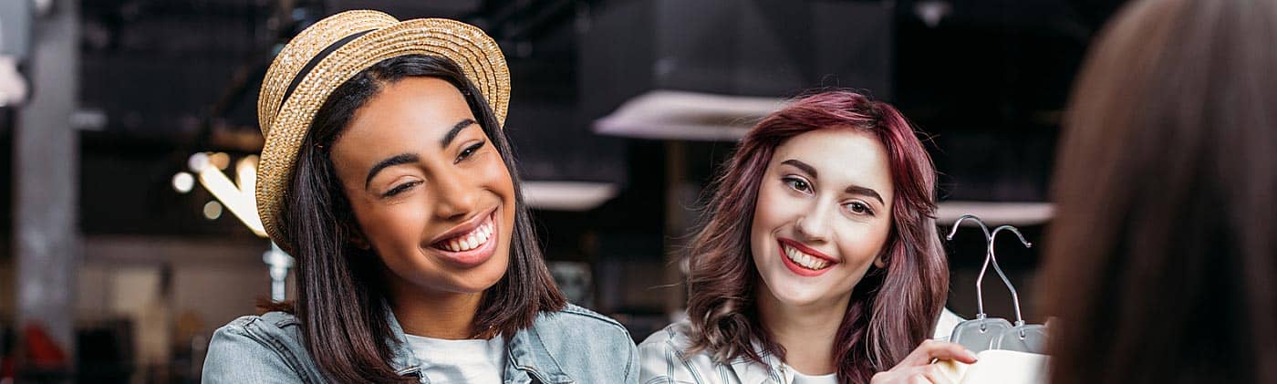 two young women buy clothes with credit card and know the importance of establishing good credit