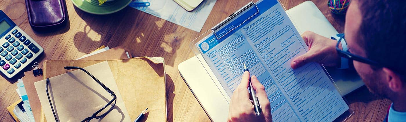 Man fills out a job application at home: losing a job
