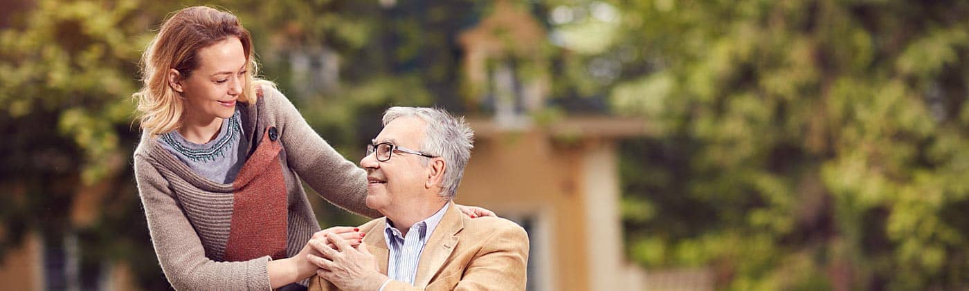 Man in wheelchair with caretaker daughter in courtyard: What does critical illness insurance cover?