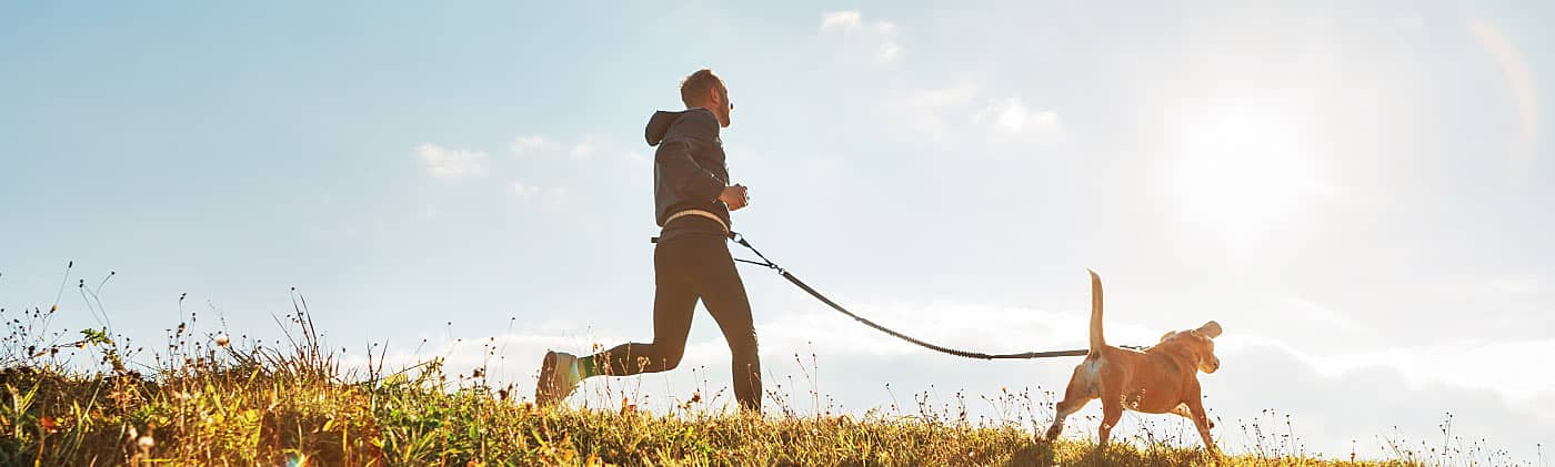 Man on a run with his dog on a sunny day after wondering what is an HSA 