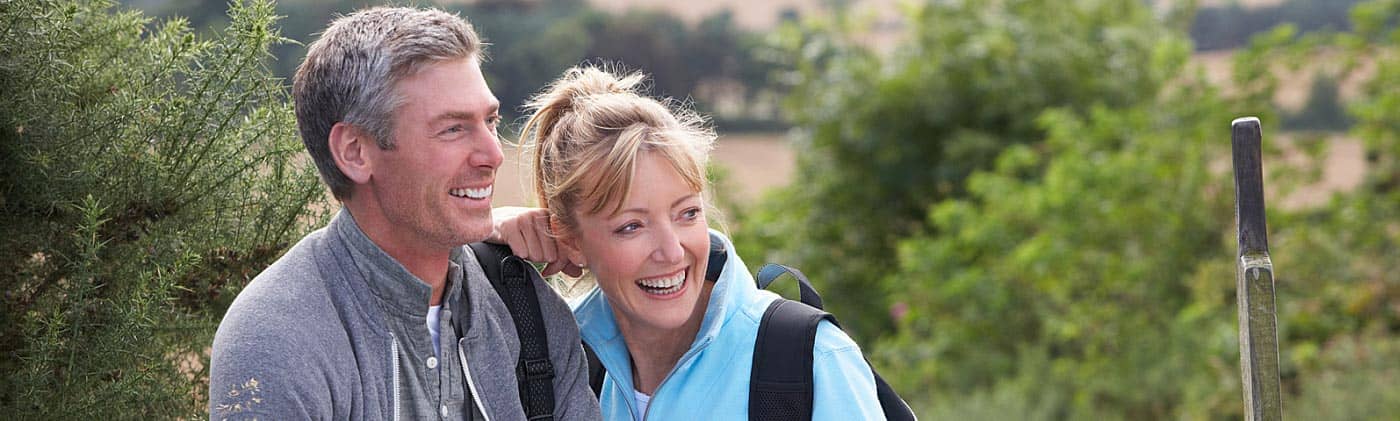 middle-aged couple checks map on hike as they consider buying convertible term life insurance