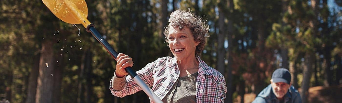 mature couple leaves shore to kayak and commits to staying financially fit in their 50s, 60s and beyond