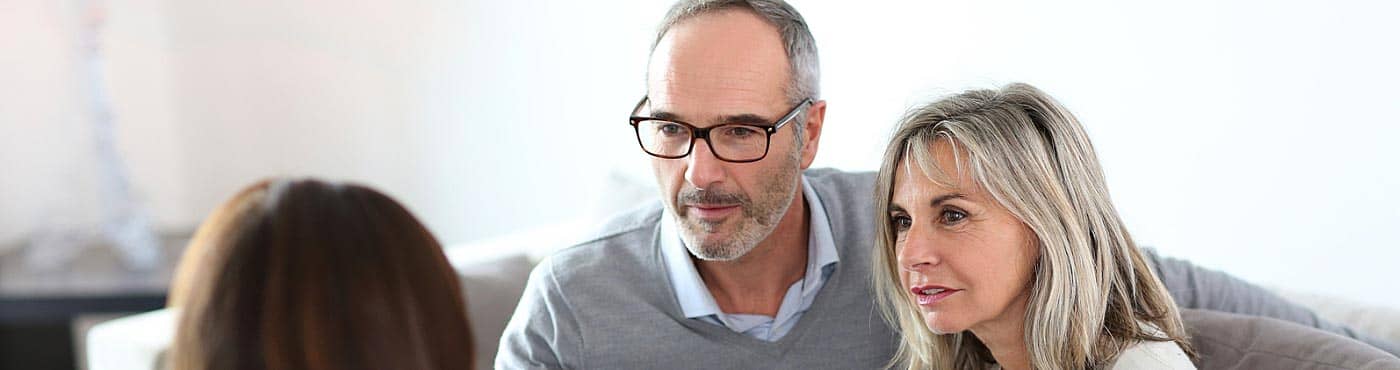 Mature couple meeting with financial advisor to discuss investments: investing after retirement