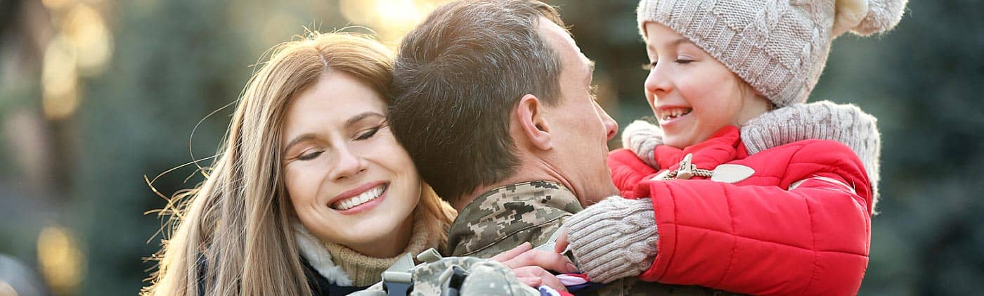 Military serviceman returning home and hugging his wife and child: life after the military