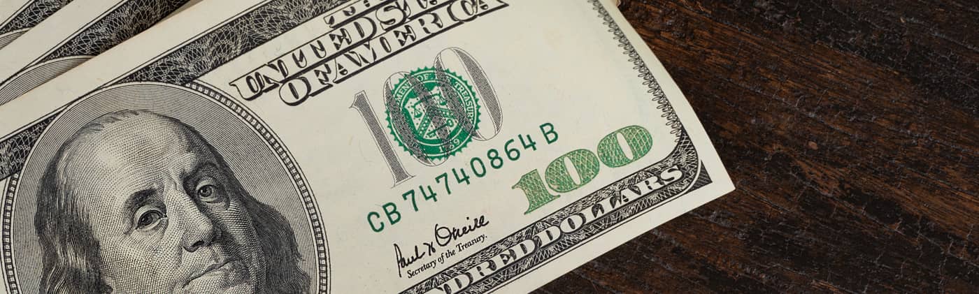 one hundred dollar bills on a table