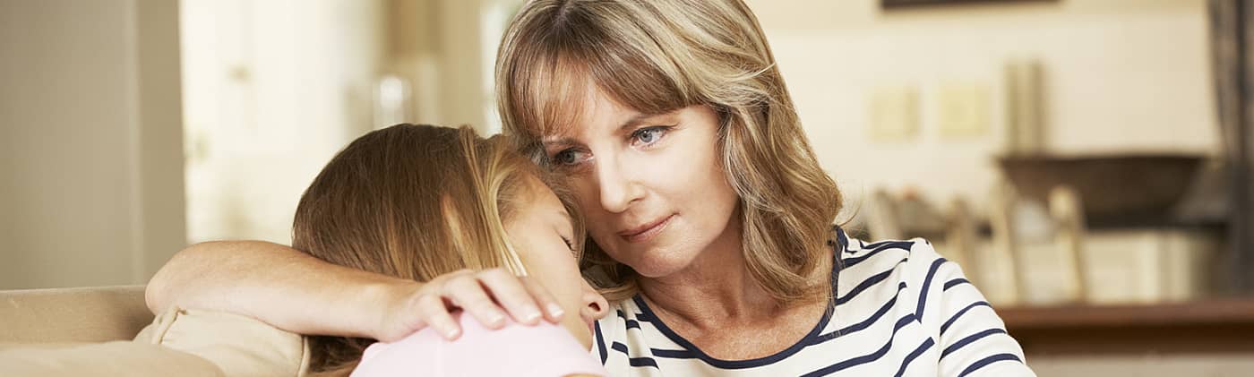 mother comforts young daughter and considers a financial planning checklist as they grieve loss of father