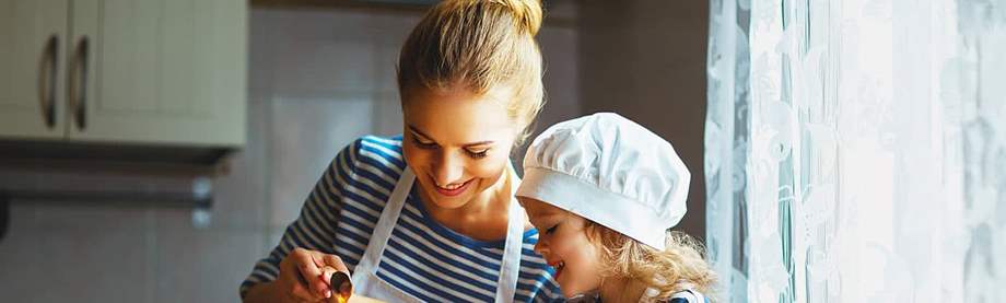 mom cooks with daughter after researching difference between accidental death insurance and life insurance
