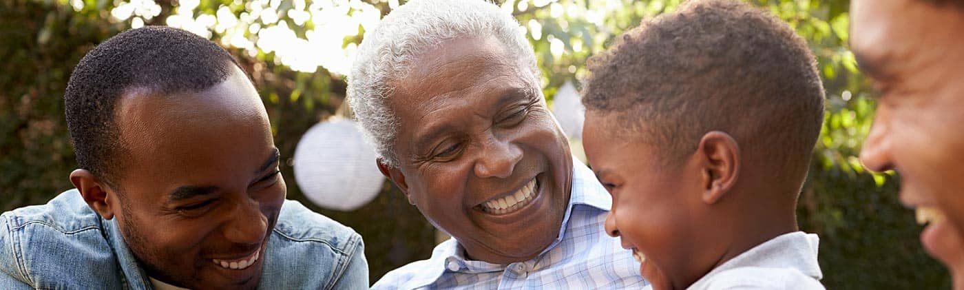 Multi-generational family smiling in their backyard: universal life insurance