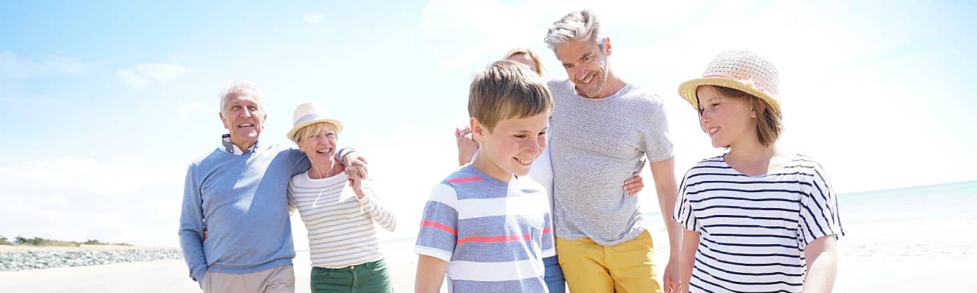 Multigenerational family walking on the beach and discussing death benefit taxes 