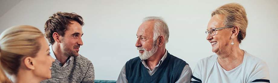 Multiple generations sitting on a couch discussing estate tax vs. inheritance tax