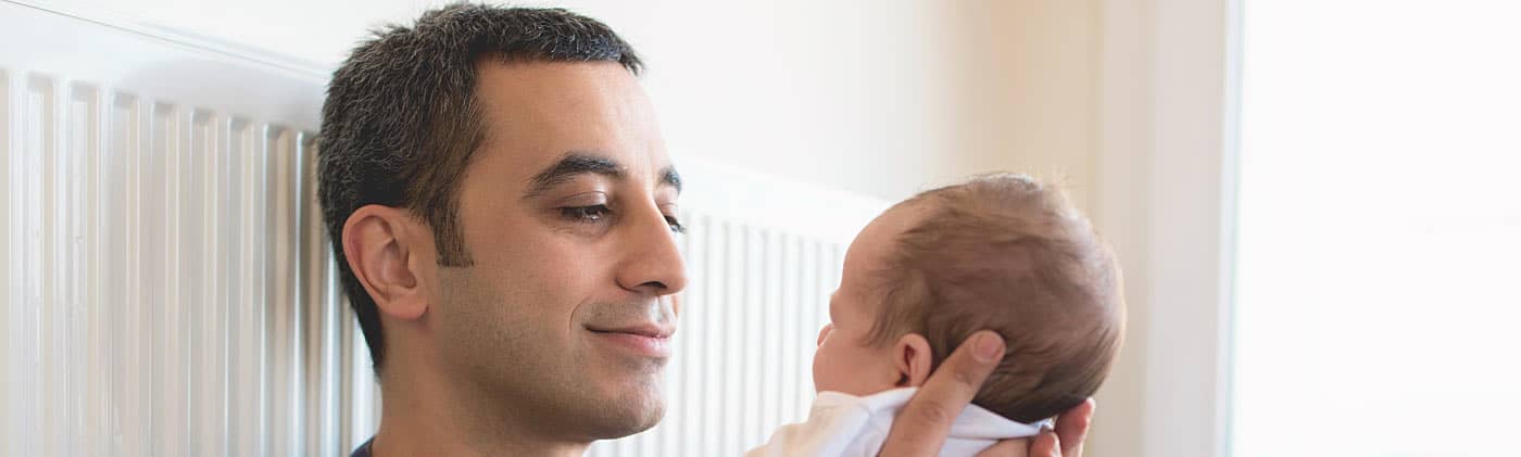 New parent holding their newborn baby consider life insurance for new parents 