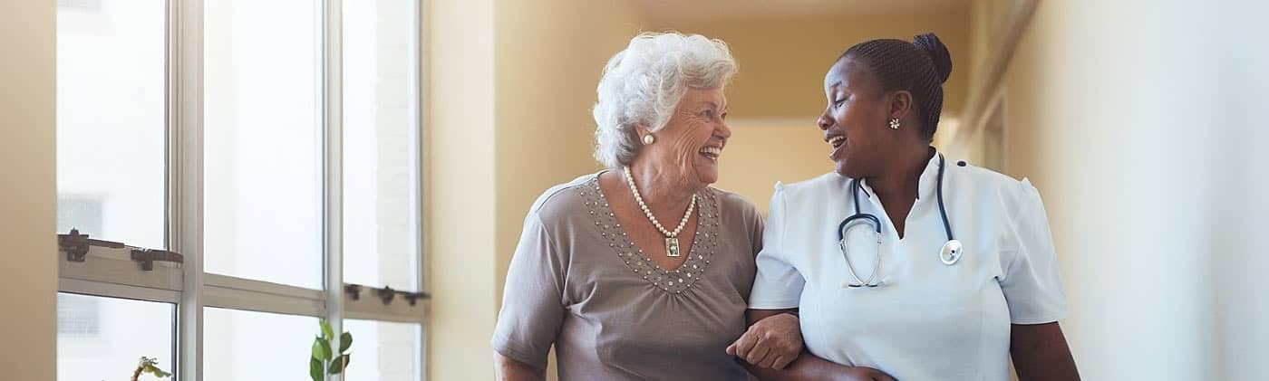 Nurse aiding a senior woman who uses the benefits of long-term care insurance to cover care fees 