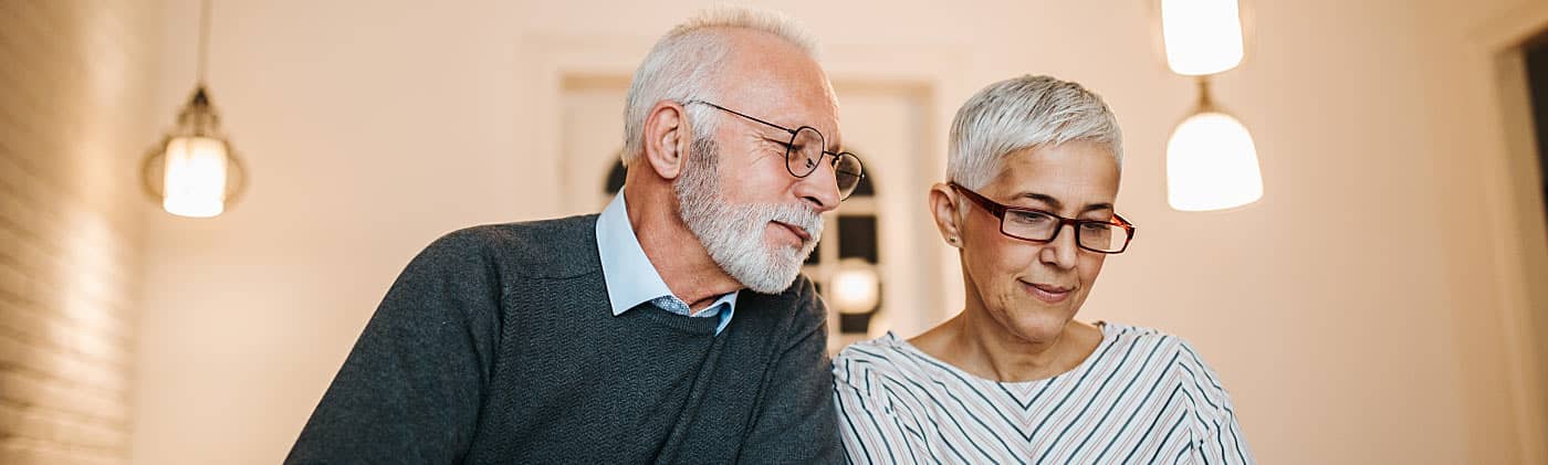 older couple doing paperwork and planning their retirement budget 