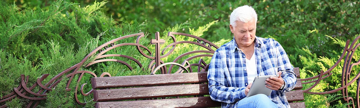 Older man reading on a park bench about hybrid mutual funds 